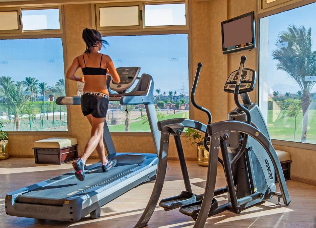 Sieviete skrien uz skrejceliņa Sunrise Garden Beach Resort sporta zālē ar skatu uz dārzu.