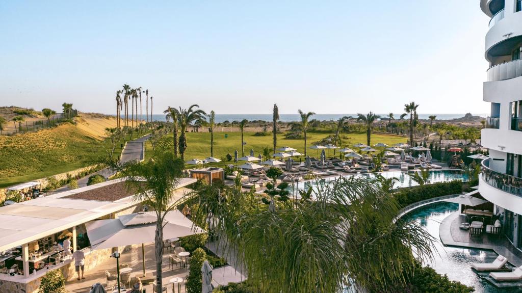 Skats uz baseinu un jūru no LIU Resorts, kur palmām apkārt ir atpūtas zonas.