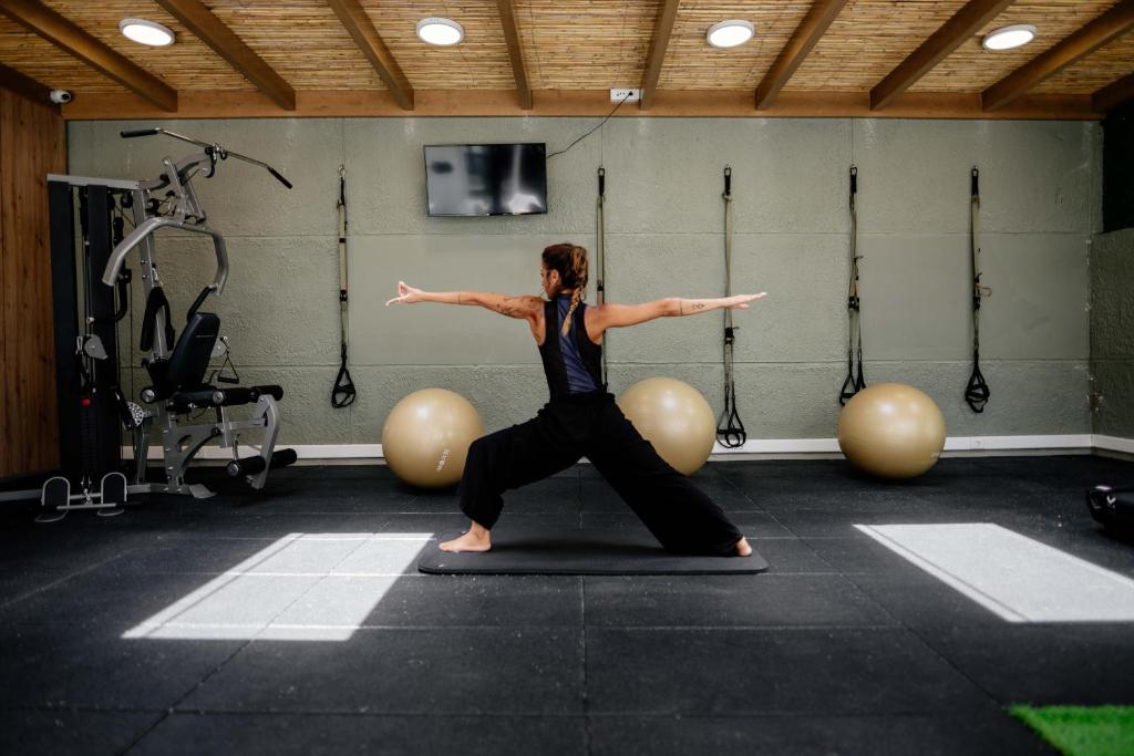 Sieviete veic jogas pozas treniņu Infinity Blue Boutique sporta zālē.