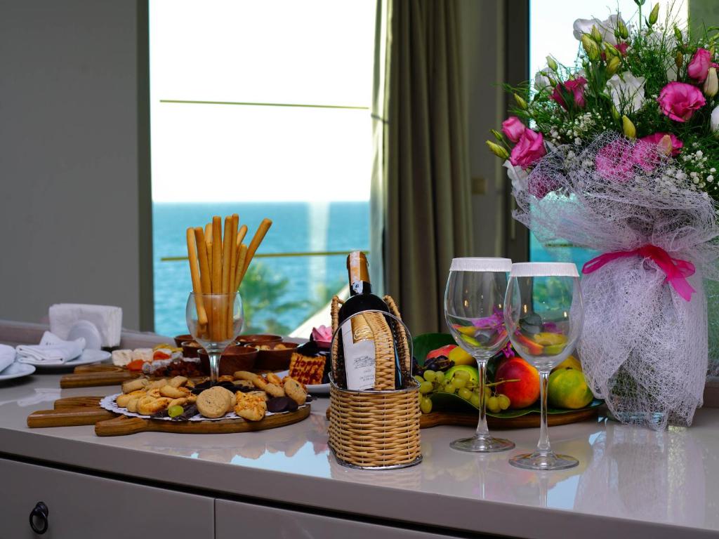 Saldumu un dzērienu klāsts pie Blue Dreams Resort & Spa numura loga, ar skatu uz jūru.