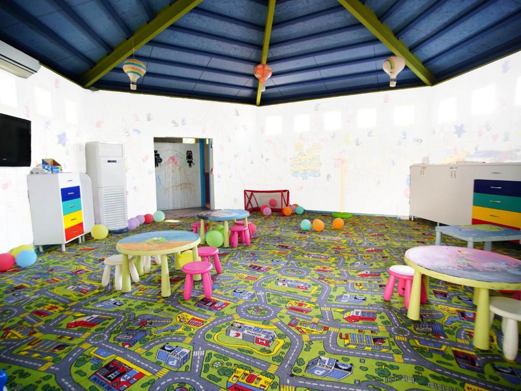 Bērnu rotaļu telpa Blue Dreams Resort & Spa ar krāsainām mēbelēm un paklāju.