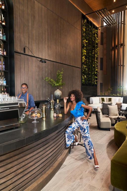 Viesnīcas LUX* Grand Baie bārs ar apkalpošanas darbinieku un viesi.