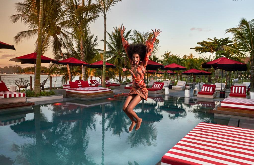 Sieviete lēkā pie baseina LUX Grand Baie viesnīcā, piekrastē.
