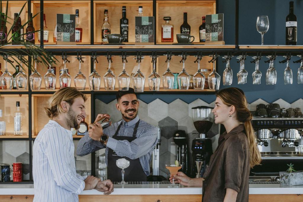 Viesnīcas Infinity Blue Boutique bārā draudzīgs bārmenis pasniedz dzērienu viesiem.