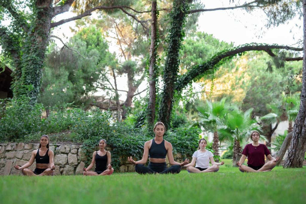 Meditācija grupā pie Papillon Belvil zaļajā dārzā.