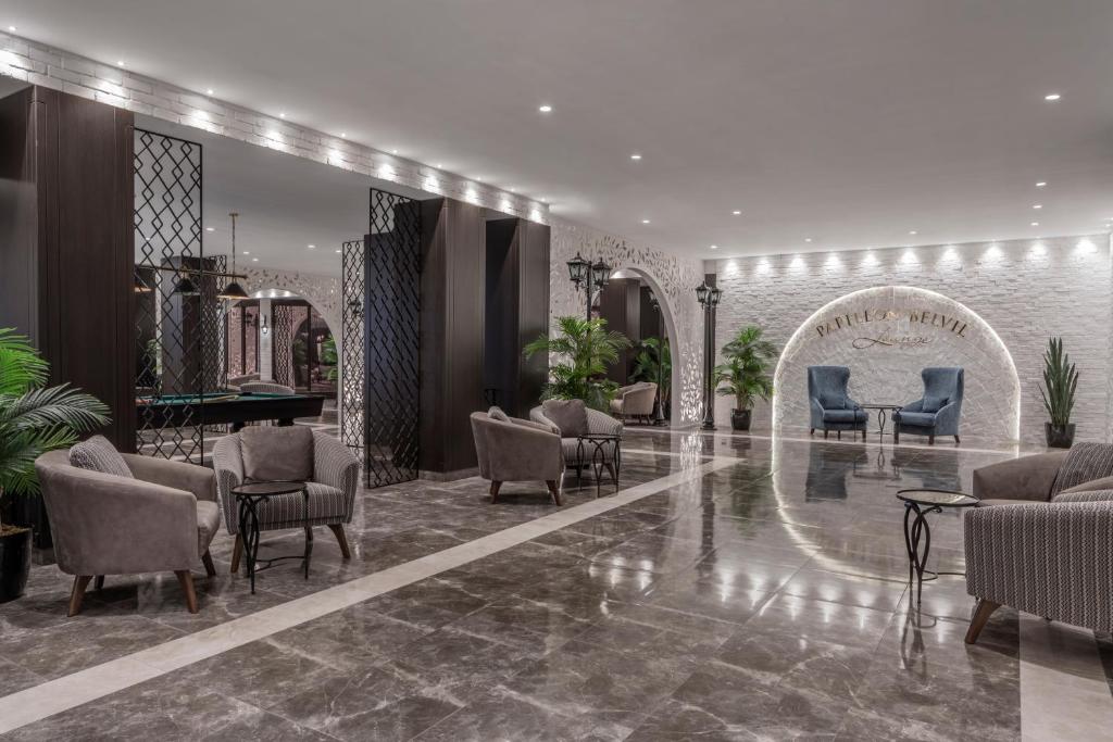Papillon Belvil viesnīcas mūsdienīgs vestibils ar elegantiem krēsliem un dekoratīvām augu kompozīcijām.