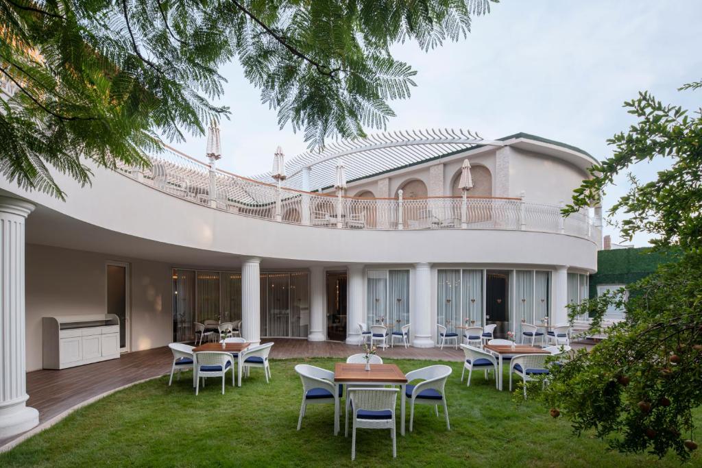 Papillon Belvil viesnīcas terase ar galdiem un krēsliem pie dārza