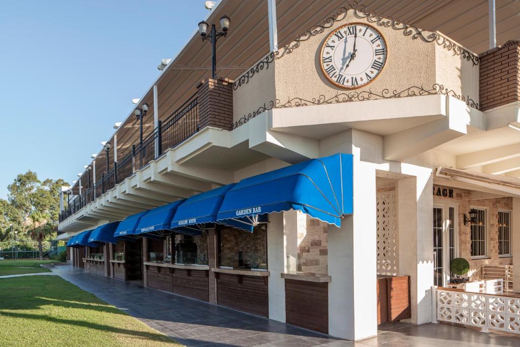 Papillon Belvil viesnīcas dārza bārs ar zilu jumtu un pulksteni