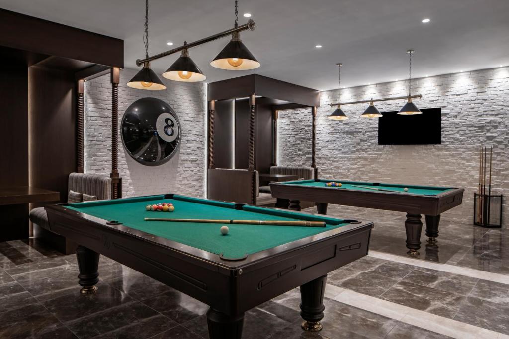 Biliarda zona viesnīcā Papillon Belvil ar diviem galdiem un modernu interjeru.