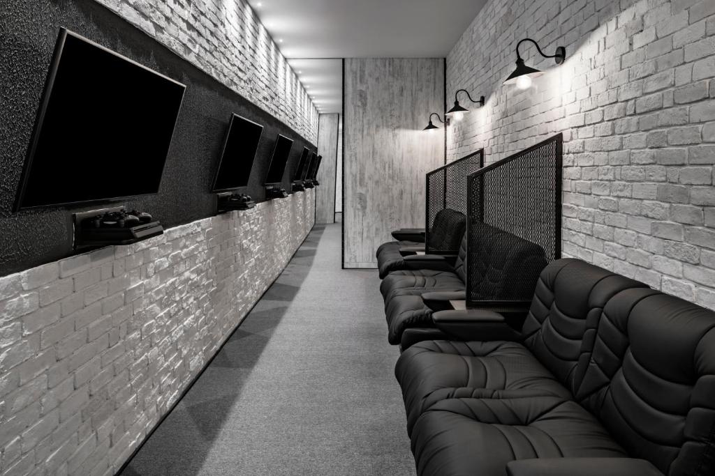 Mūsdienīgs spēļu istabas interjers viesnīcā Papillon Belvil ar melnām ērtiem krēsliem.