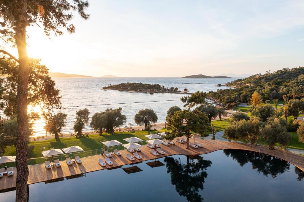 Skats uz Rixos Premium Bodrum piekrasti ar baseinu un saulrietu