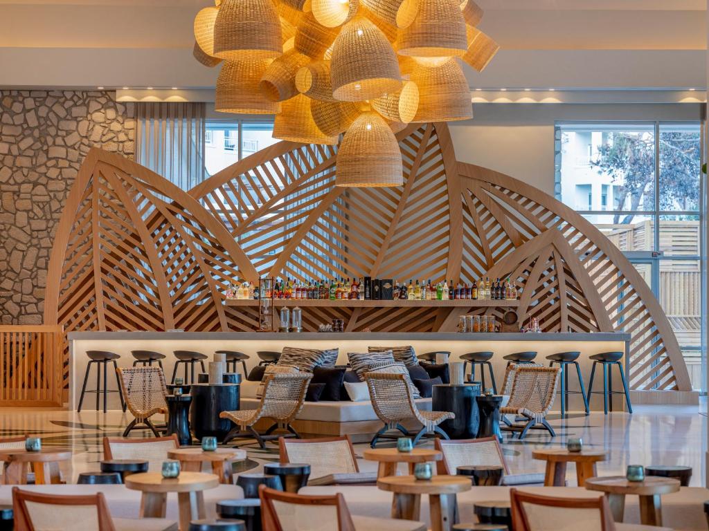 Moderns bārs Rixos Premium Bodrum ar stilīgu koka dizainu un labi apgādātu dzērienu plauktu.