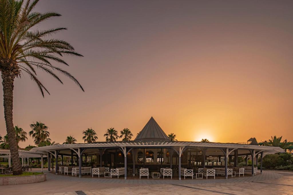 Vasaras terase pie viesnīcas Papillon Belvil saulrieta gaismā