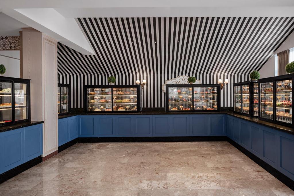 Mūsdienīgs desertu stends viesnīcā Papillon Belvil ar melnbaltu sienu dizainu.