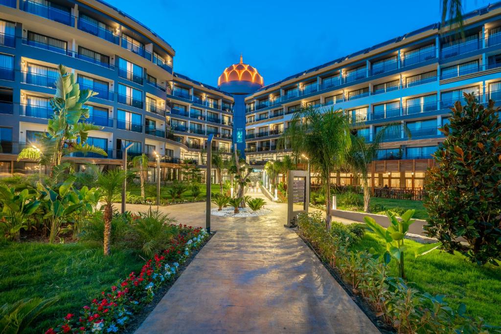 Pastaiga uz Arnor De Luxe Hotel & Spa ar zaļumu un apgaismojumu.