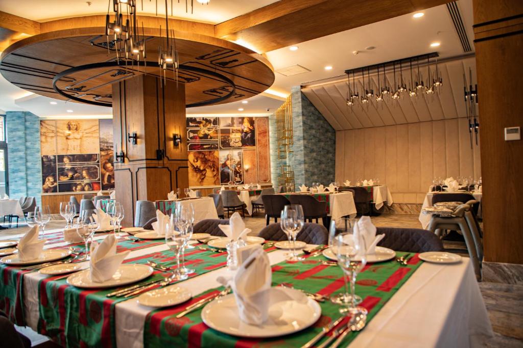 Mūsdienīgs restorāns ar eleganti klātiem galdiem Arnor De Luxe Hotel & Spa.