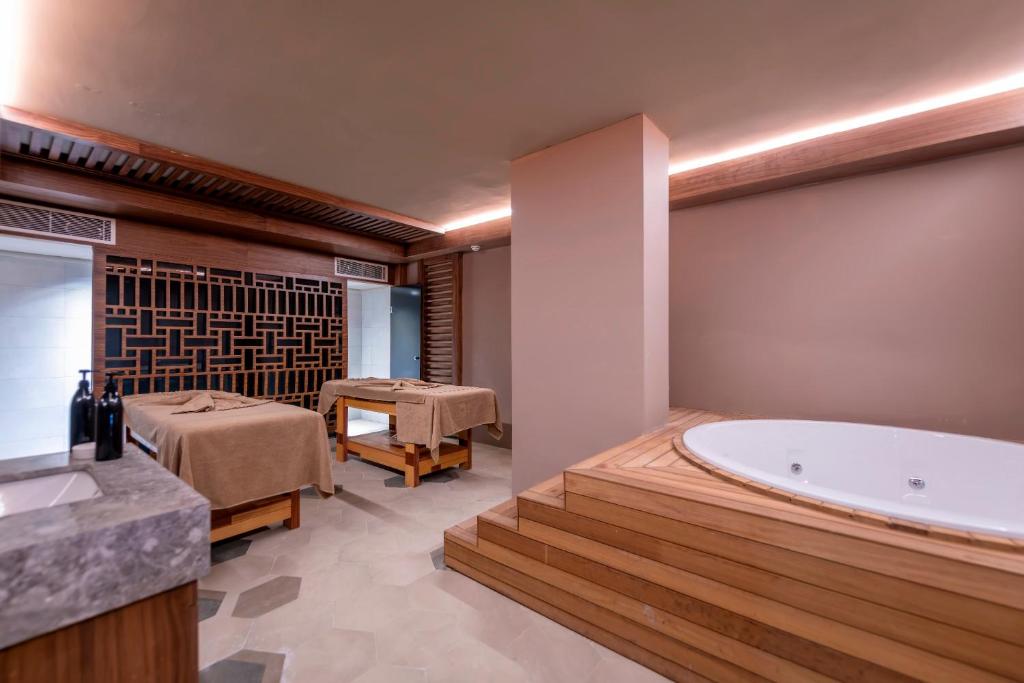 Mūsdienīgs spa interjers ar masāžas galdiem, koka akcentiem un relaksējošu atmosfēru. Telpā ir arī džakuzi, kas piedāvā relaksāciju un komfortu.