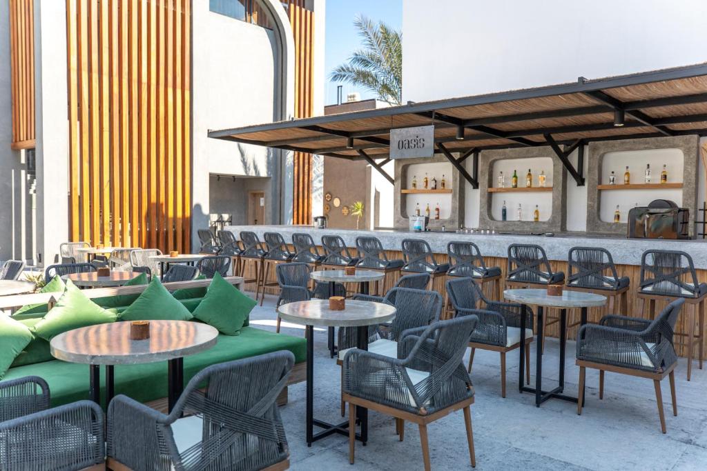 Oasis bārs Sunrise Tucana Resort ar zaļām spilveniem un elegantiem galdiem