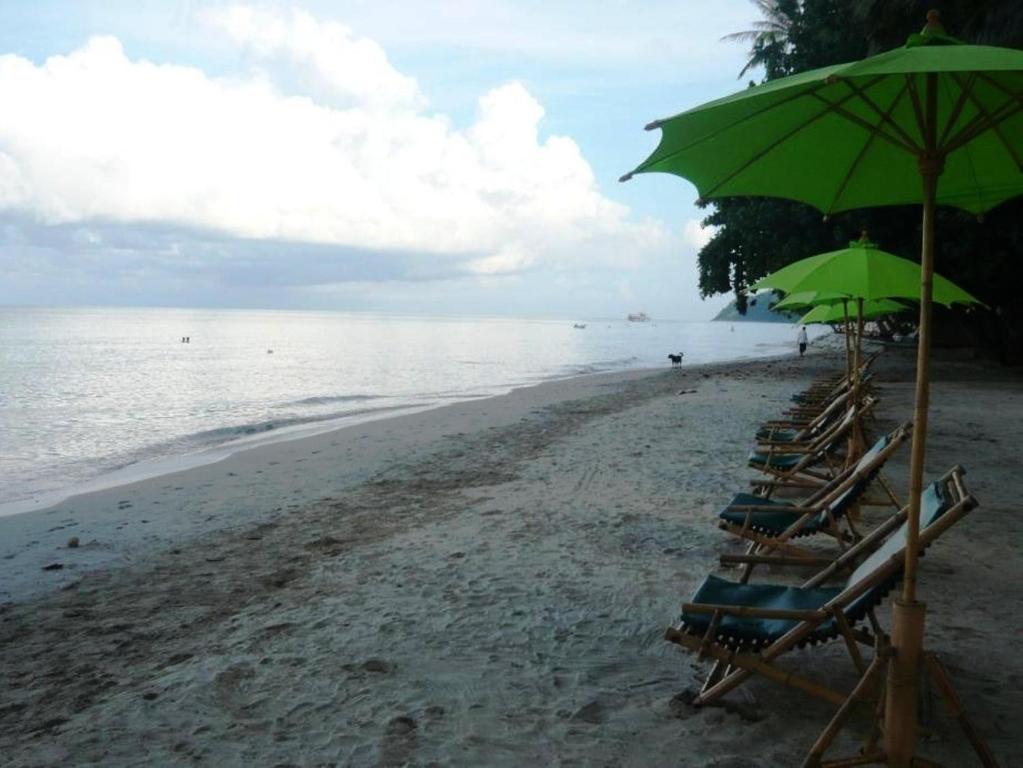Skaista pludmale ar zaļiem saules aizsargiem pie Banpu Koh Chang.