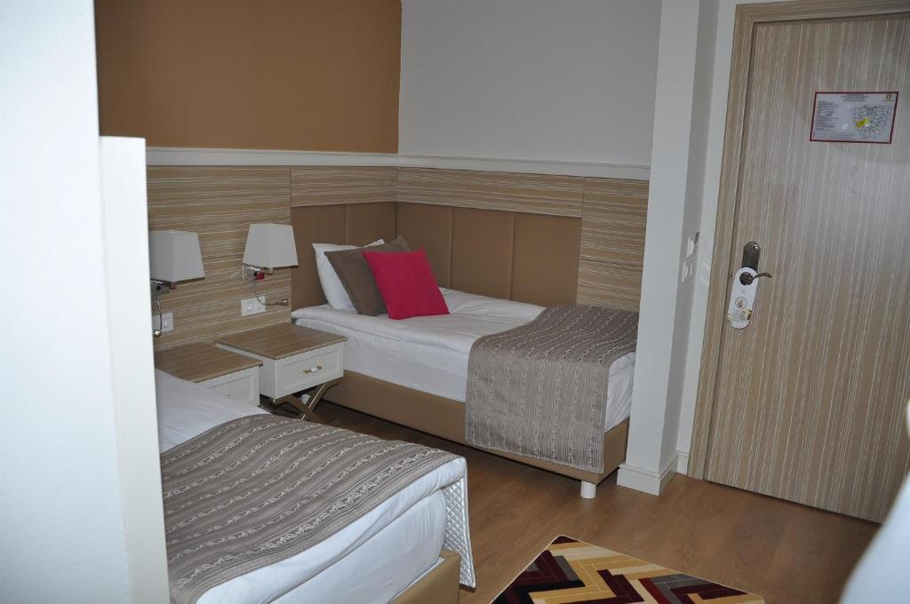 Moderns numurs viesnīcā Delphin Deluxe ar divām gultām un elegantu interjeru.