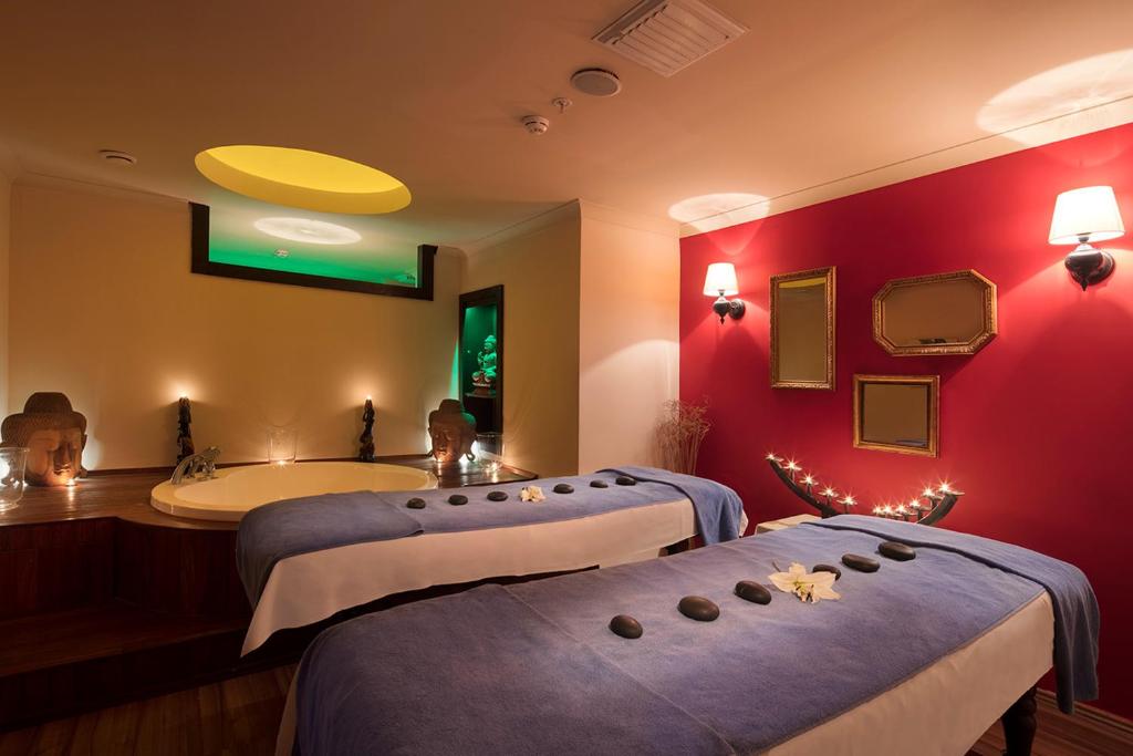 Saphir Hotel & Villas spa telpa ar mājīgām masāžas galdiem un romantisku apgaismojumu.