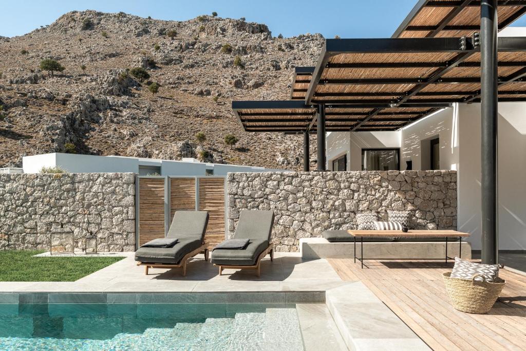 Mūsdienīgs terases skats pie Casa Cook Rhodes ar baseinu un kalnu fonu.