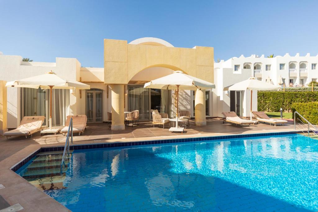 Baseina zona pie Sunrise Select Diamond Beach Resort ar saules krēsliem.