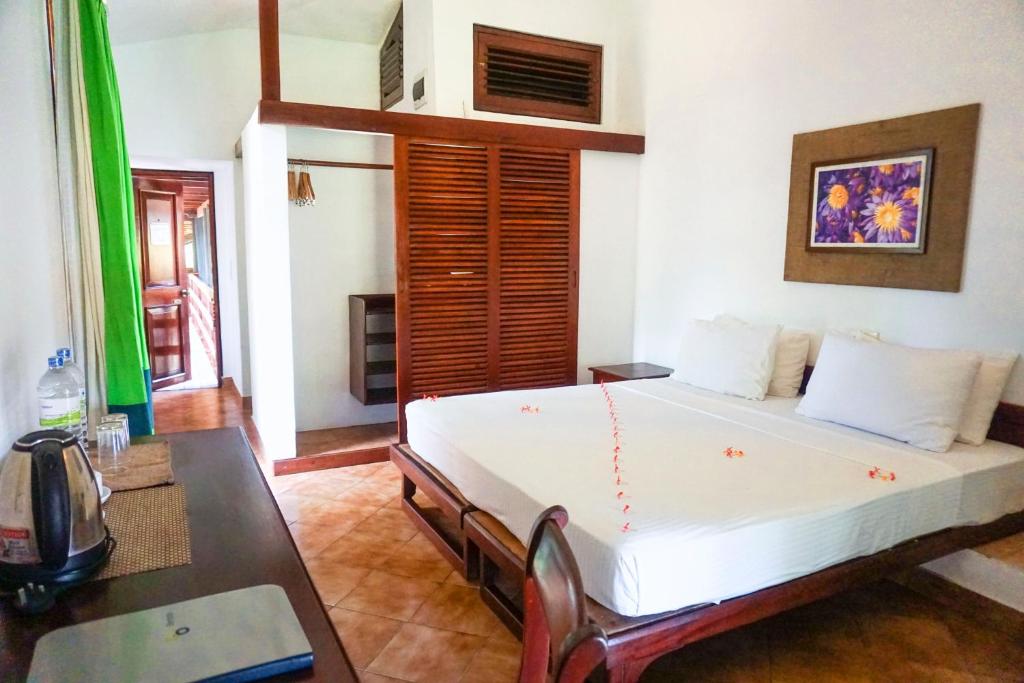 Club Bentota viesnīcas numurs ar divguļamo gultu un koka interjeru.