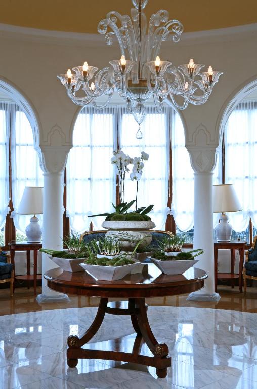 Eleganta ieejas zona Grande Albergo Delle Rose ar šarmantu lustru un ziediem.