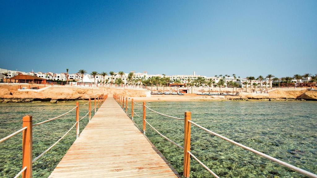 Koka piestātne piekrastē, Sunrise Grand Select Montemare Resort fonā.