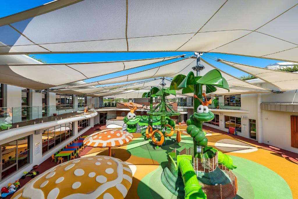 Bērnu rotaļu laukums pie Cornelia Diamond Golf Resort & Spa, zaļi un krāsaini elementi.