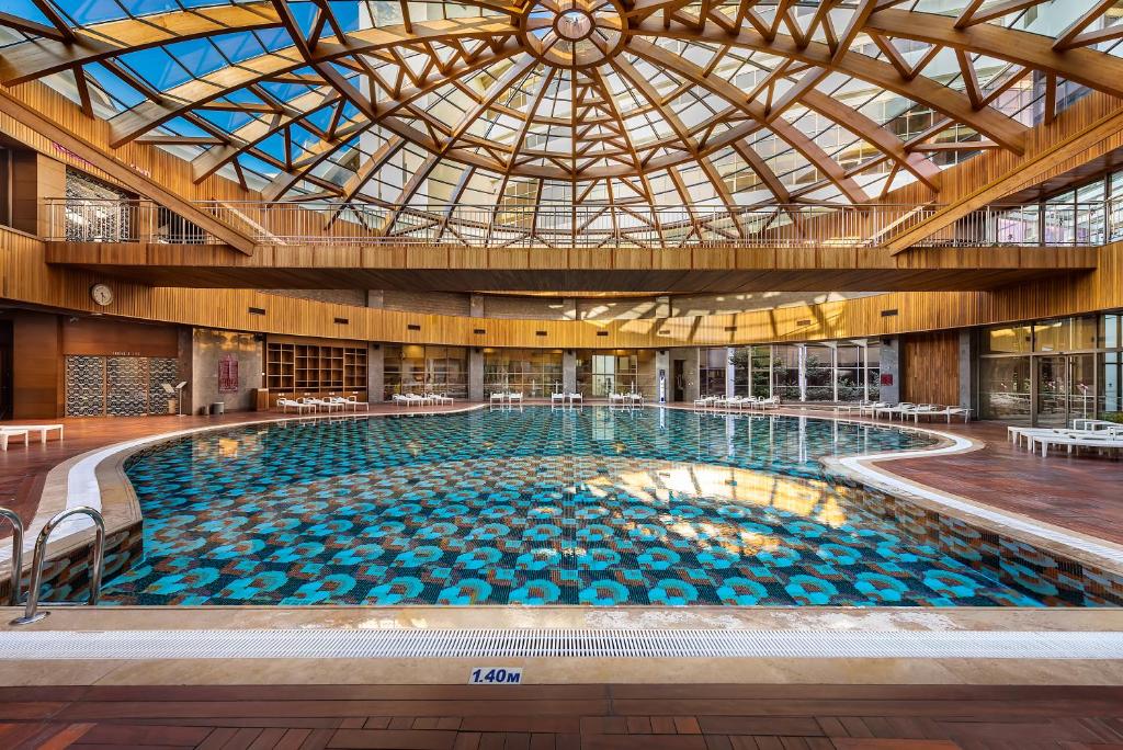 Iekšējais peldbaseins Cornelia Diamond Golf Resort & Spa ar stikla jumtu.