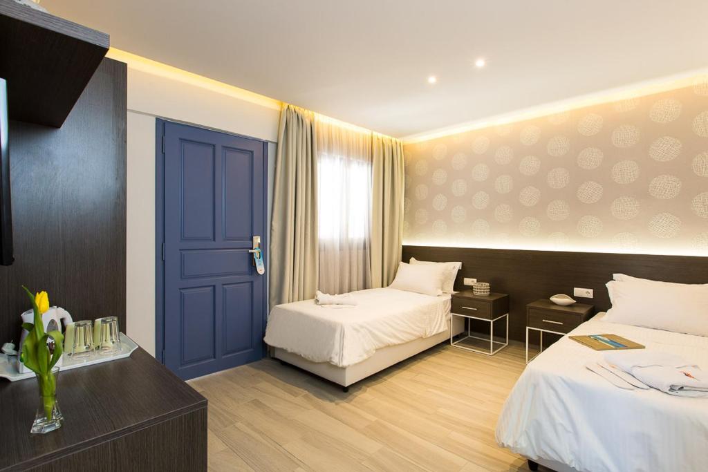 Mūsdienīga viesnīcas numura iekārtojums ar divām gultām, gaišām sienām un elegantu apgaismojumu. Numurā ir televizors, naktsgaldiņi un dabiska gaisma no loga.