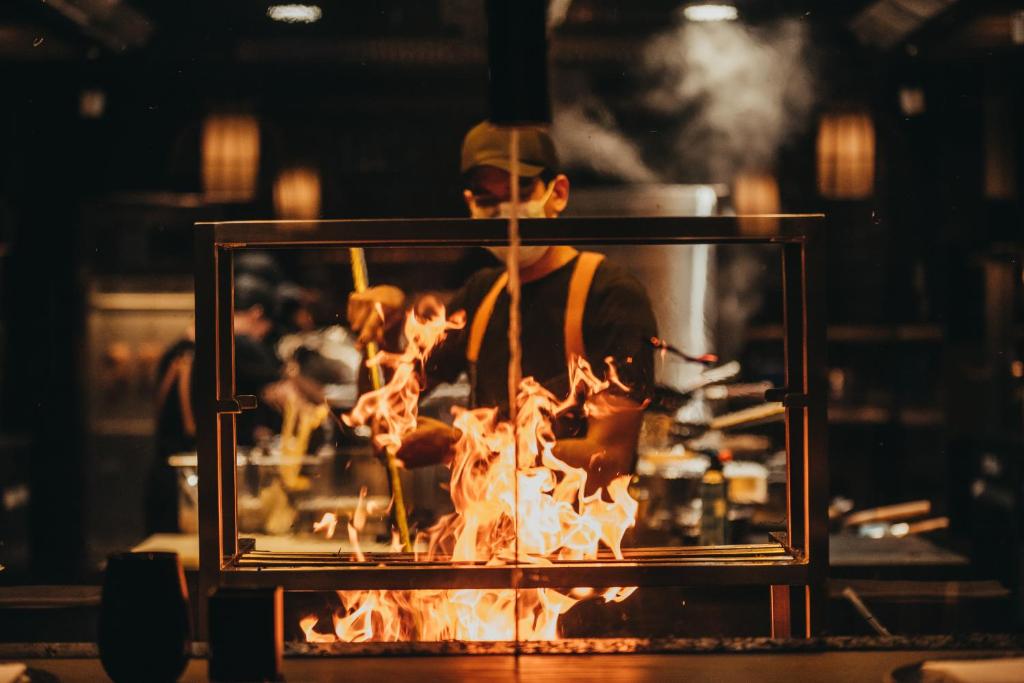 Virs pavārs gatavo ēdienus ar liesmu LUX Grand Baie restorānā.