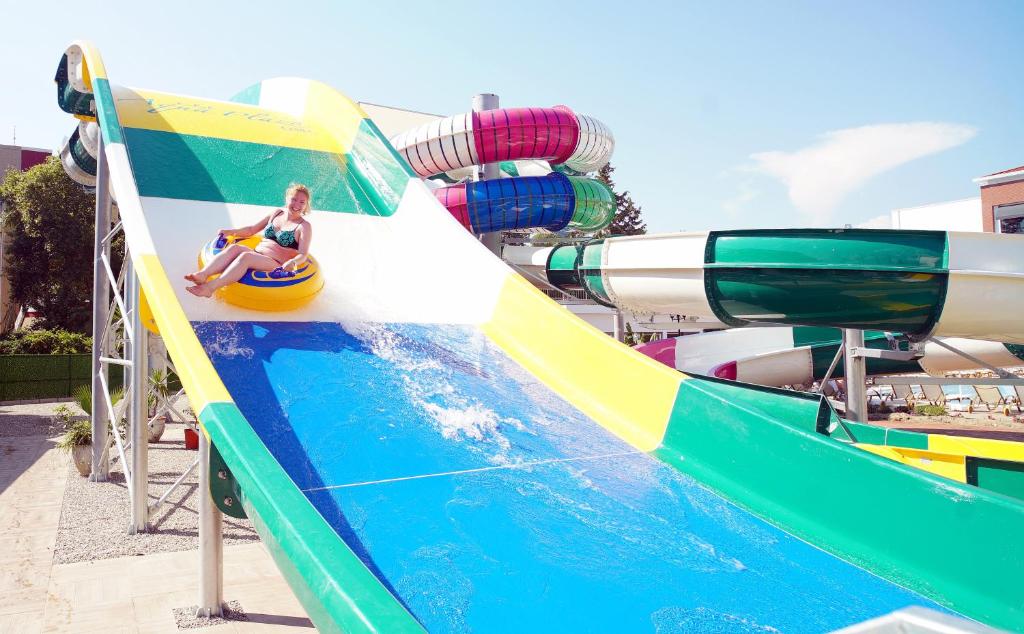 Bērns jautrībā slīd pa ūdens slidkalniņu viesnīcā Club Aqua Plaza.