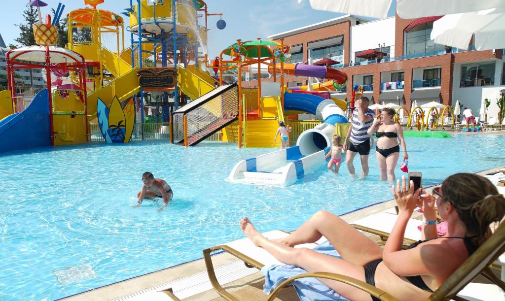 Bērni izbauda ūdens slidkalniņus pie Club Aqua Plaza baseina.