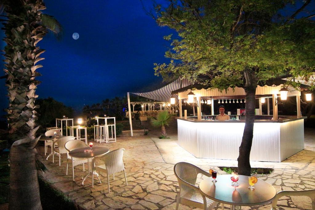 Bārs pie Club Aqua Plaza piekrastē ar dzērieniem un apgaismojumu naktī.