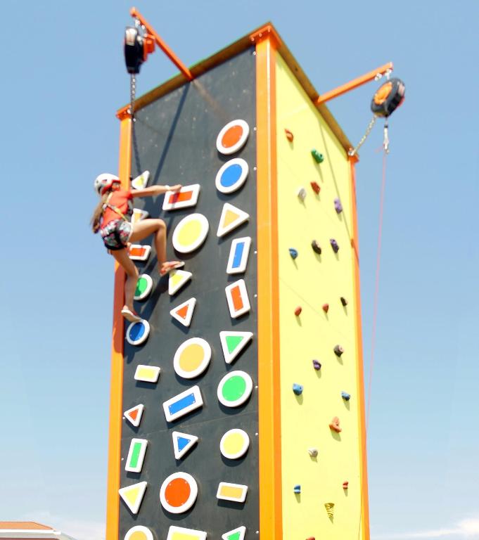 Bērns kāpj uz mākslīgā kāpšanas sienas Club Aqua Plaza