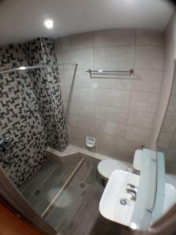 Mūsdienīgs vannas istabas interjers ar dušas stūri, izsmalcinātiem flīžu rakstiem un modernām sanitārajām ierīcēm. Vannas istaba ir gaiša un funkcionāla.