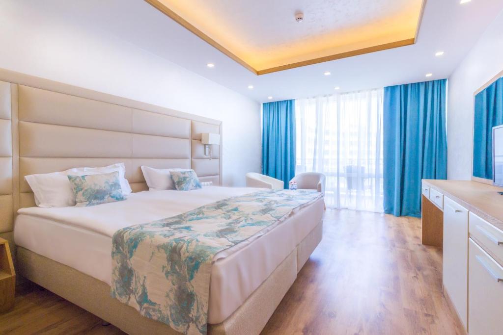 Mūsdienīgs viesnīcas numurs ar divām gultām, gaišām krāsām un lieliem logiem, kas nodrošina dabisko apgaismojumu. Interjers ir elegants ar koka grīdu un modernām mēbelēm.