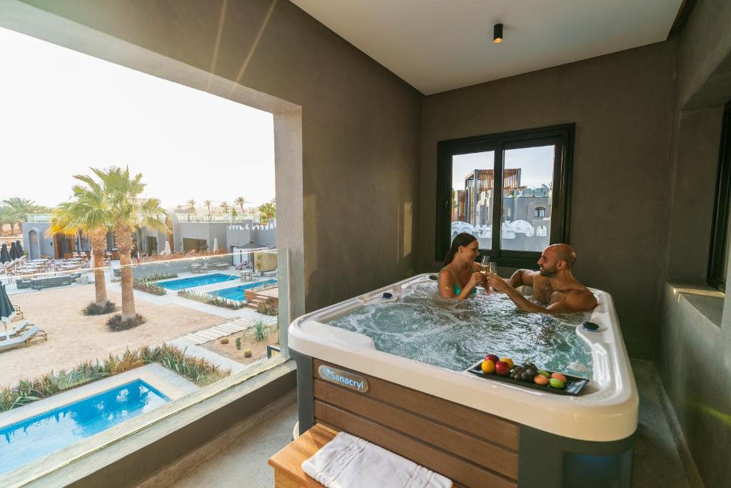 Pāris relaksējas džakuzi Sunrise Tucana Resort ar skatu uz baseinu.