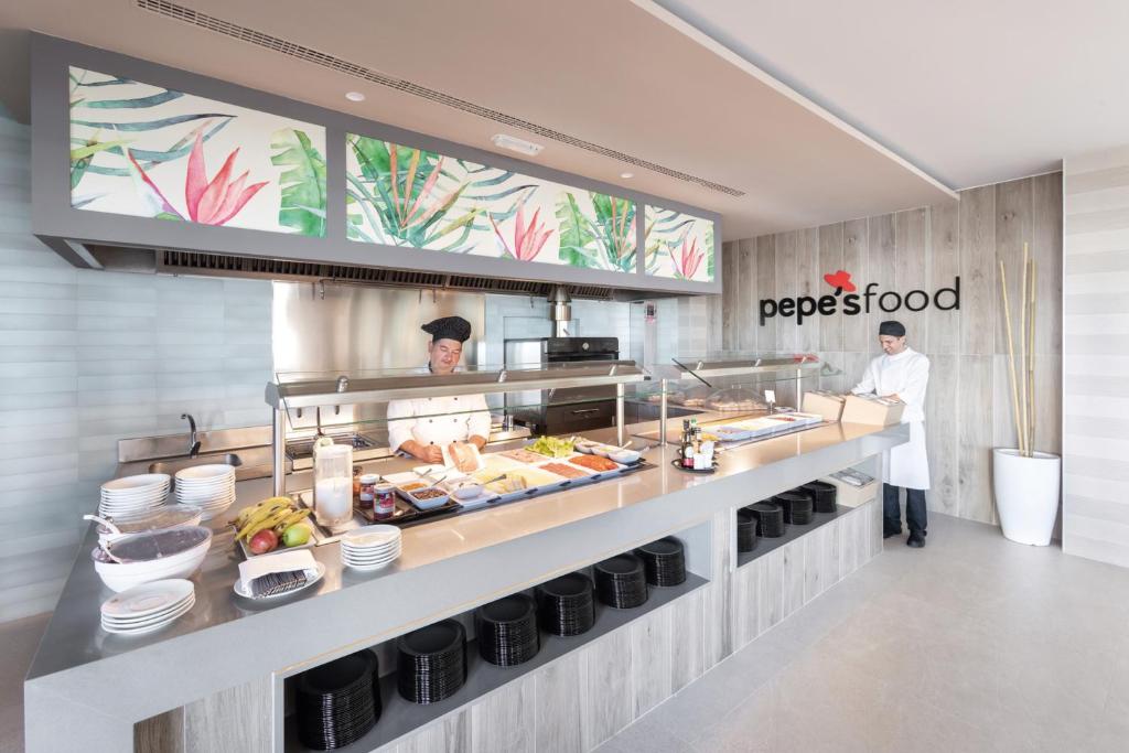 Šefpavārs gatavo ēdienus pie Riu Madeira ēdināšanas stacijas.