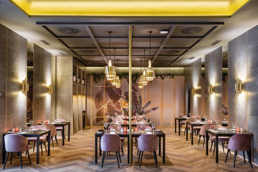 Mūsdienīgs restorāns viesnīcā Riu Madeira ar elegantiem galdiem un apgaismojumu.