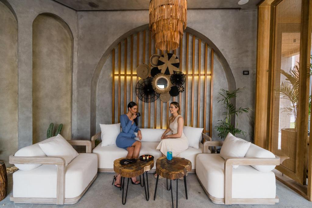 Divas sievietes atpūšas modernā viesnīcas Sunrise Tucana Resort interjerā.