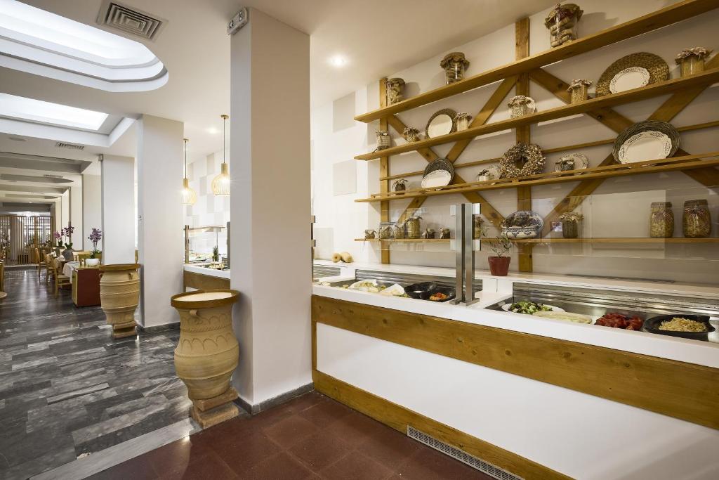 Mūsdienīgs restorāna interjers ar koka plauktiem, kas dekorēti ar traukiem un augiem, un bufete, kurā pieejami svaigi dārzeņi un ēdieni. Gaisīgā un siltā atmosfērā ir redzami koka un akmens elementi.