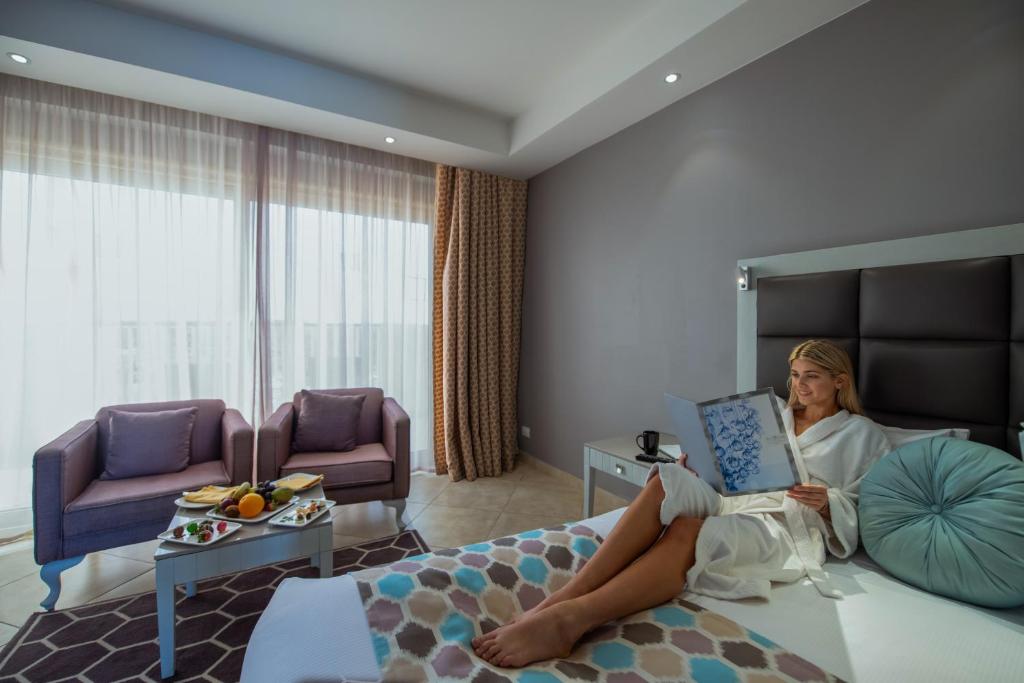 Mierīga sieviete, kas lasa ēdienkarti Sunrise Crystal Bay Resort numurā.