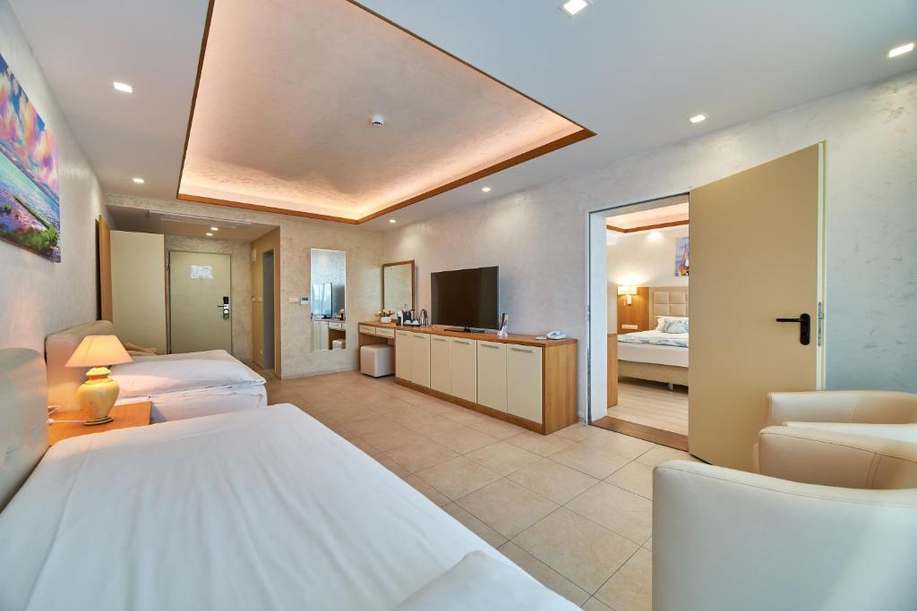 Mūsdienīgs viesnīcas numurs ar divām gultām, televizoru, mini bāru un atsevišķu vannas istabu. Telpa ir gaiša un plaša, ar skaistu ainavu uz sienas.