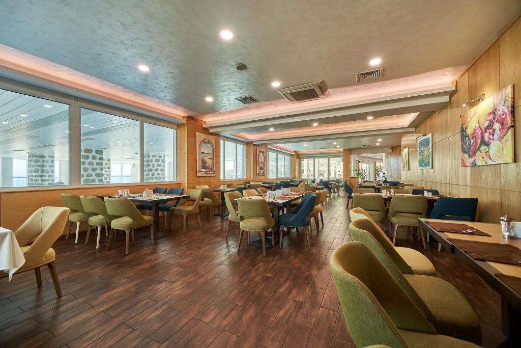 Mūsdienīgs restorāns ar koka apdari un ērtām krēslām, kas nodrošina patīkamu ēdiena baudīšanas atmosfēru. Lielas logu vitrīnas ļauj ieplūst dabiskajai gaismai, radot siltu un viesmīlīgu vidi.