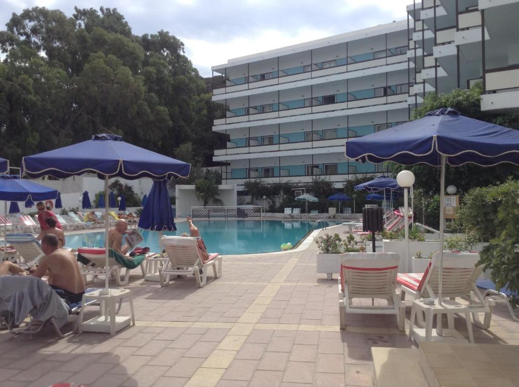 Belair Beach viesnīca, baseins un sauļošanās krēsli piekrastē.
