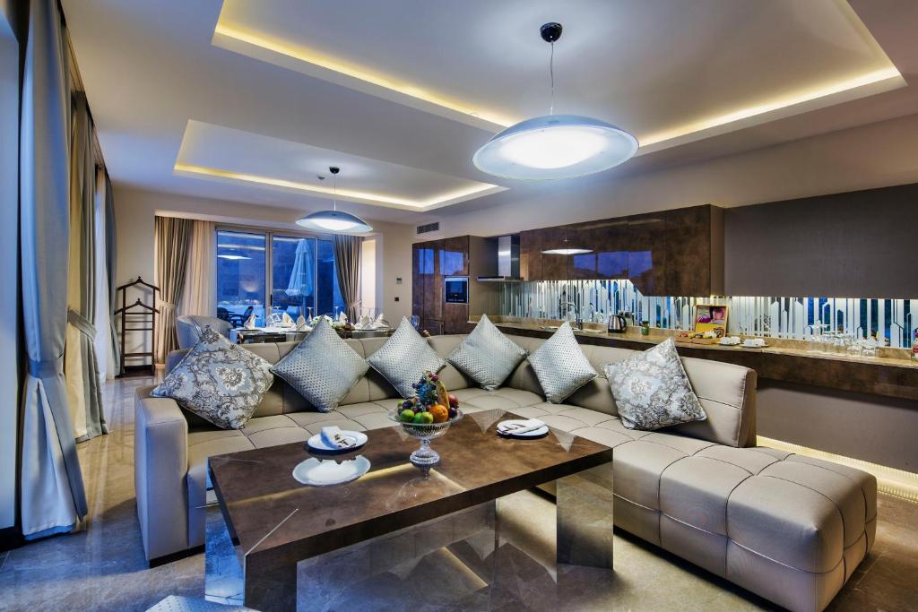 Mūsdienīgs viesnīcas numurs Bellis Deluxe Hotel ar elegantu dīvānu un ēdamgalds.